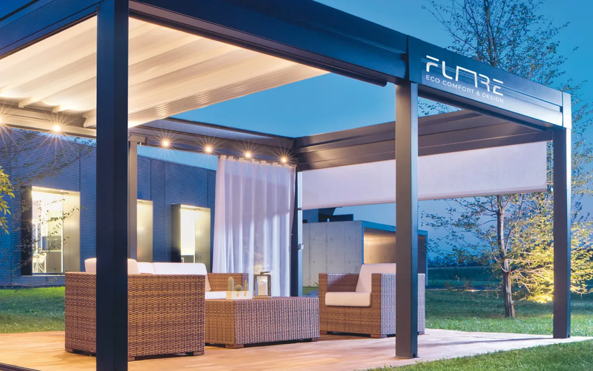 Il logotipo Flare in bianco sulla trave di una pergola, in una fotografia al crepuscolo